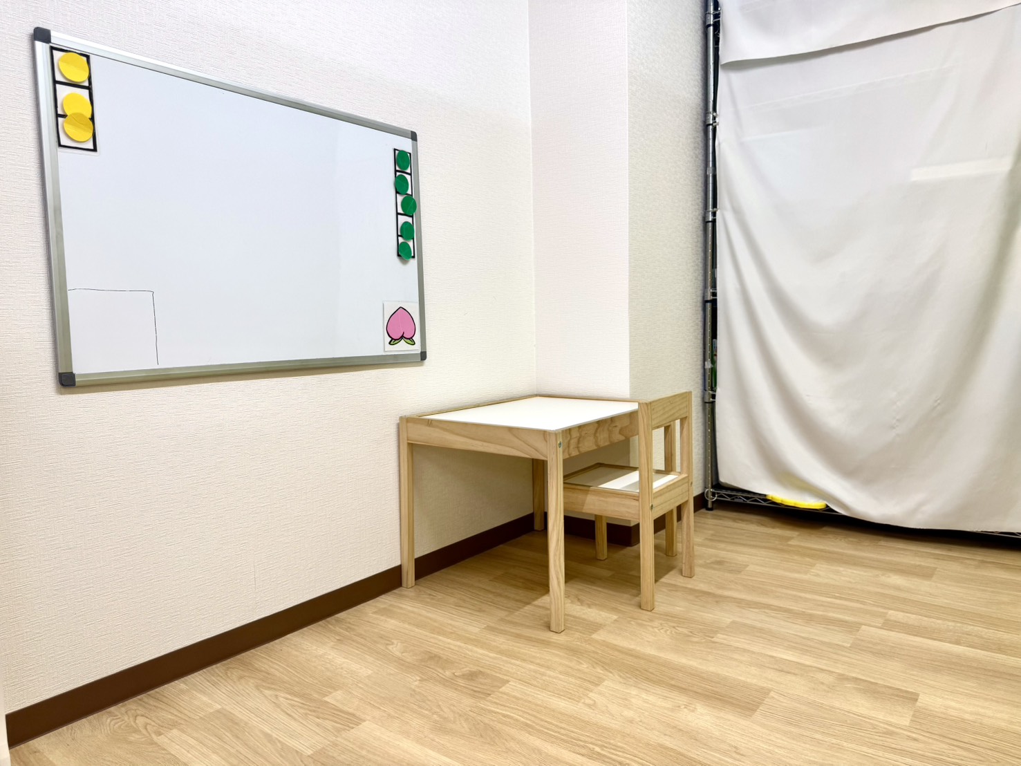 ももの個室。ホワイトボードと、子ども用の机といすが置かれている